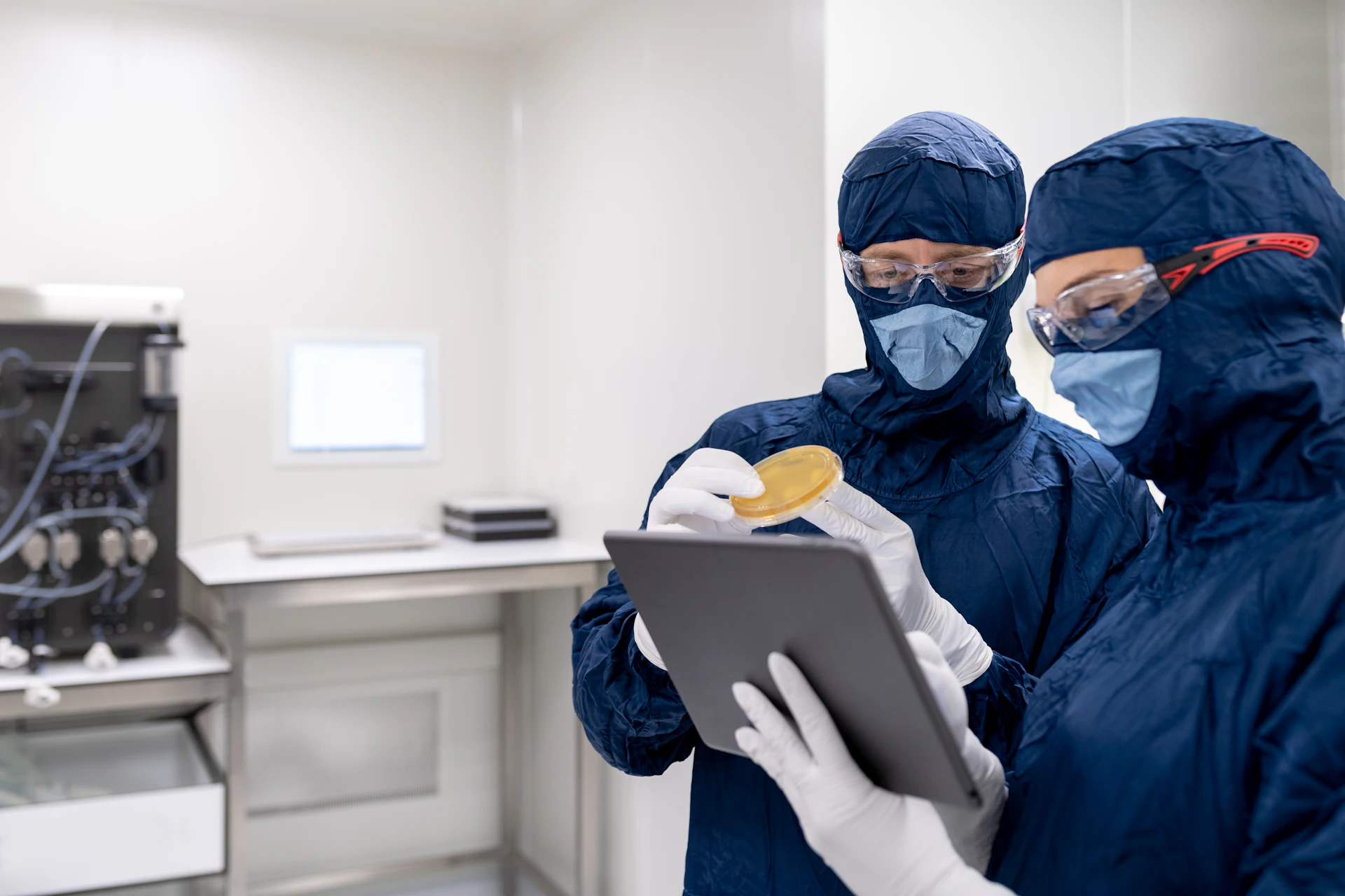 Técnicos con barbijo y guantes revisando un informe en una tablet