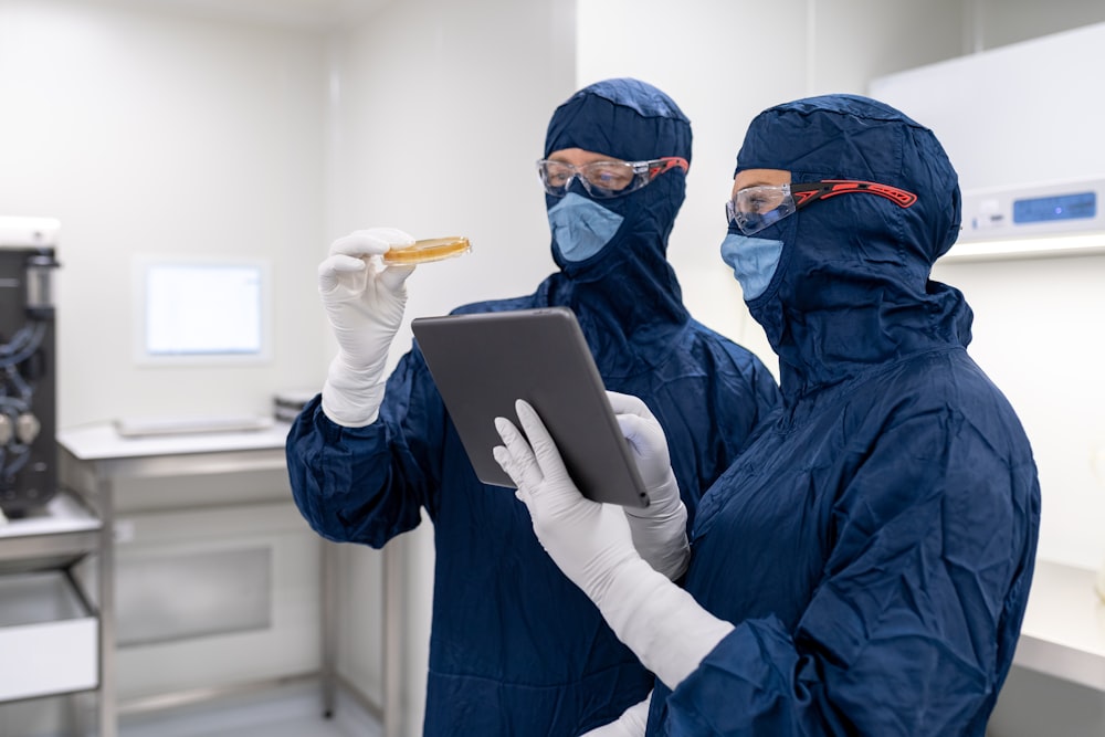 a couple of people wearing masks and holding a laptop