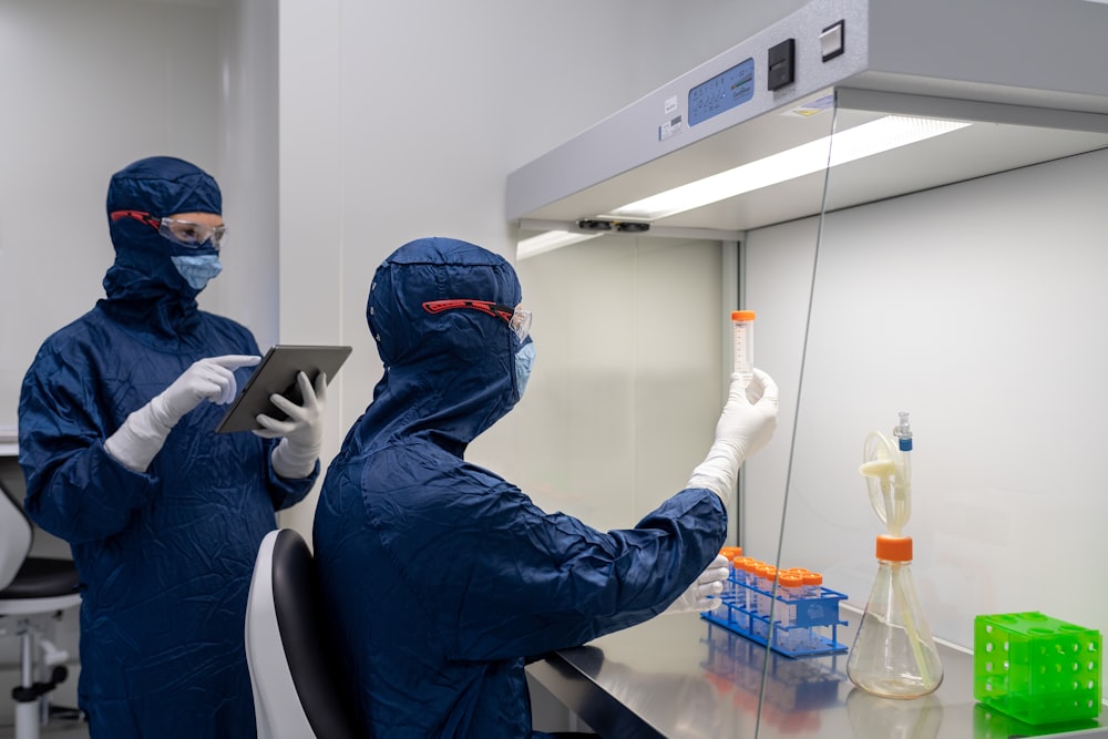 a couple of people in surgical scrubs and masks in a room