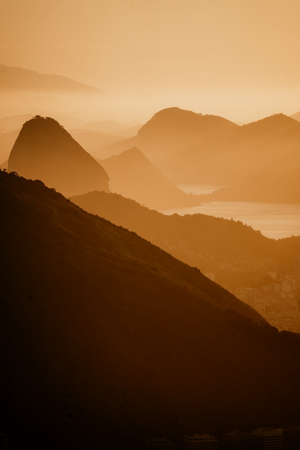 a large mountain with a body of water in the distance