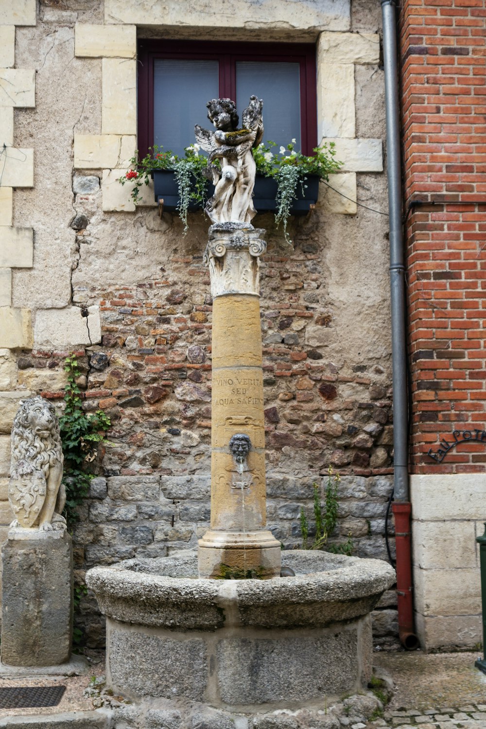 a statue of a person holding a cross in front of a brick building