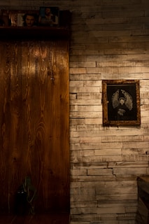 A cozy room corner featuring framed mythical creature art hanging above a wooden shelf.