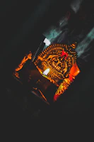 A close-up of an intricately carved wooden talisman glowing softly under candlelight.