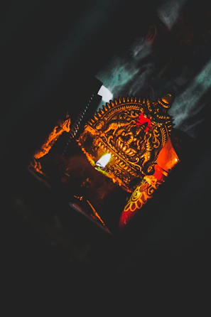 A close-up of an intricately carved wooden talisman glowing softly under candlelight.