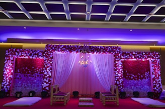 a room with pink curtains and a stage with pink lights