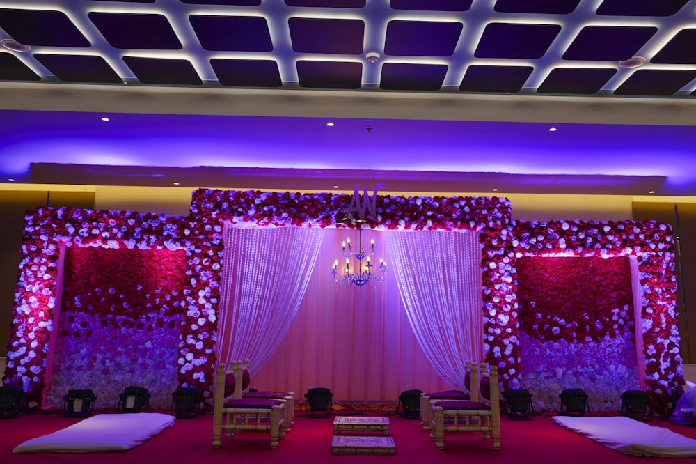 a room with pink curtains and a stage with pink lights