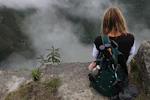 a person with a backpack looking at a foggy mountain