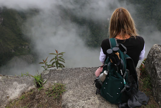 a person with a backpack looking at a foggy mountain
