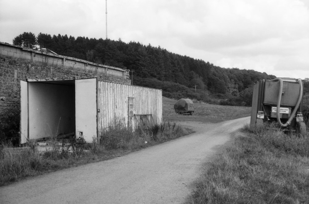 a road with a shed and a hill in the background