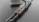 Close-up of a custom rifle with intricate engravings and polished wood finish.