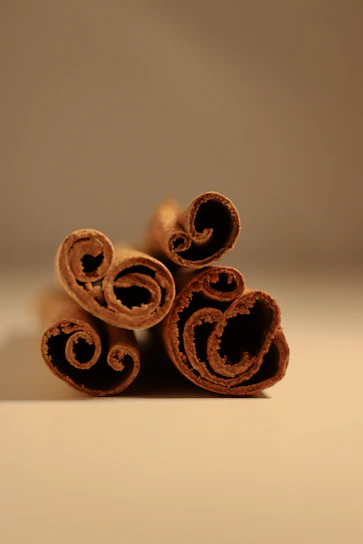 Close-up of fresh cinnamon sticks arranged on a rustic wooden table highlighting their rich texture.