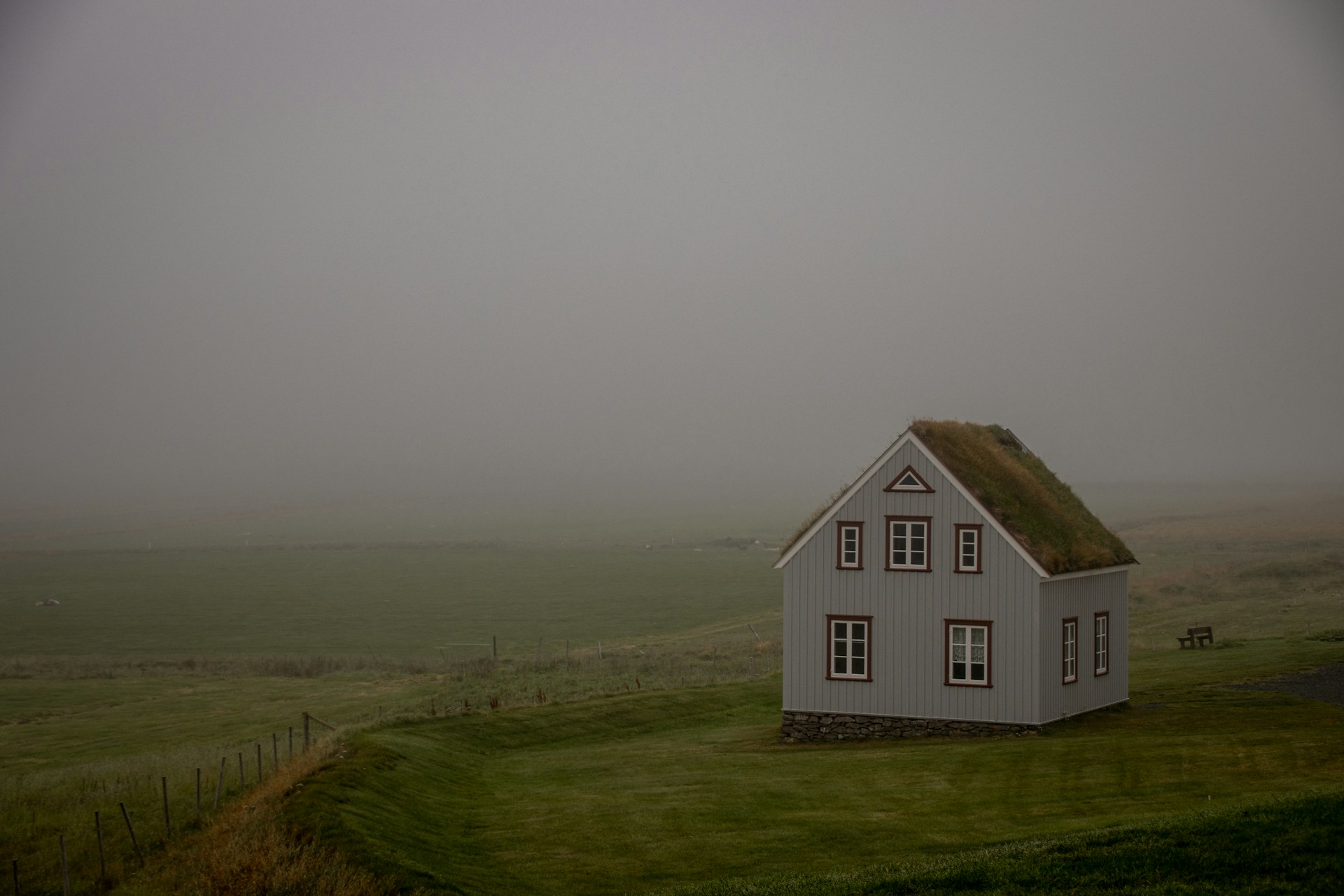 a white house on a grassy hill