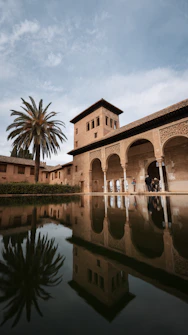 a building with a tower and a palm tree in front of it