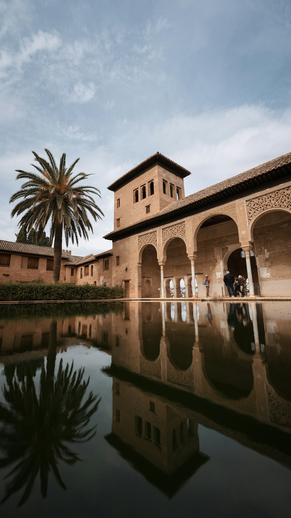 a building with a tower and a palm tree in front of it