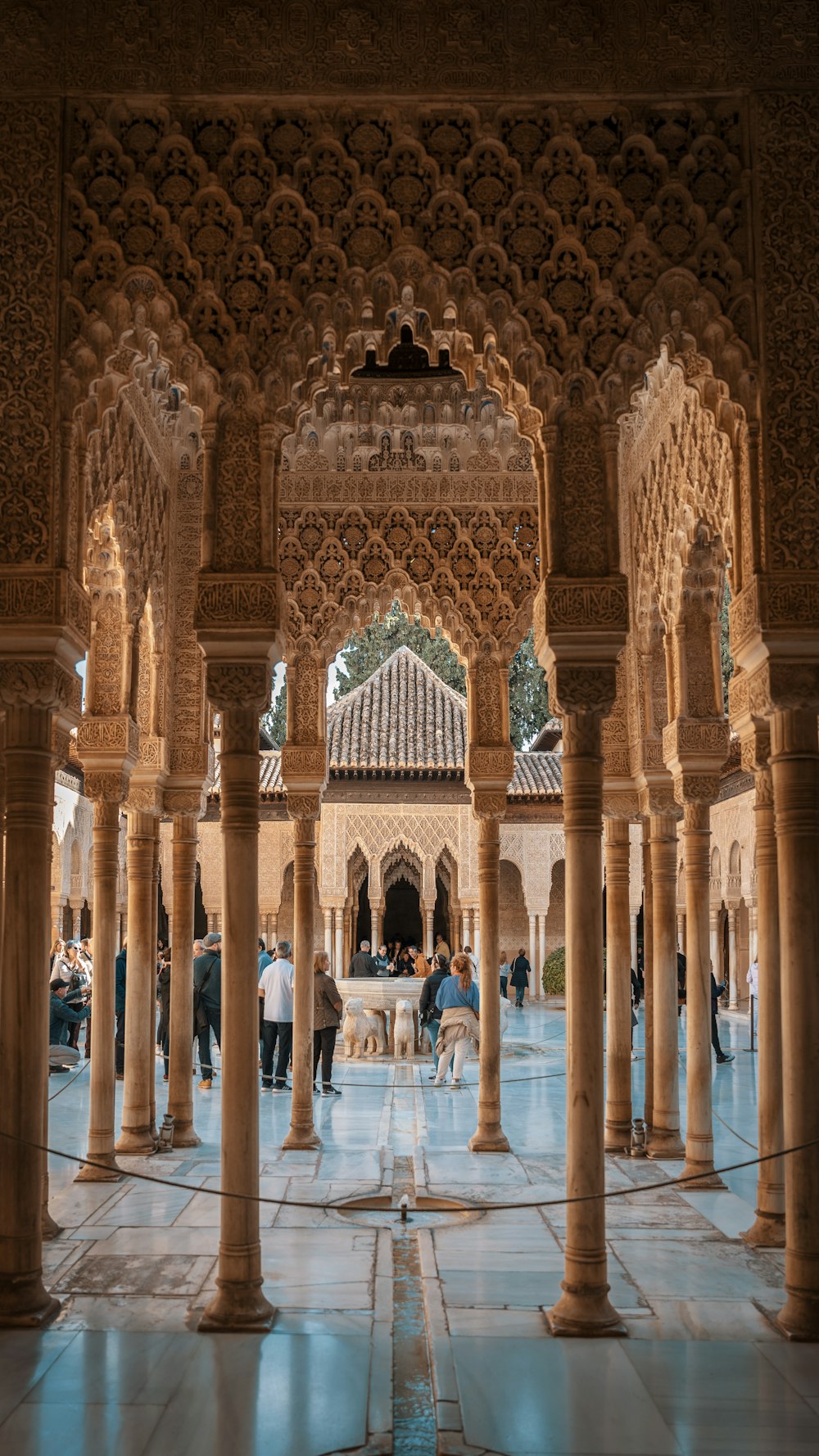 a group of people walking through a building with columns