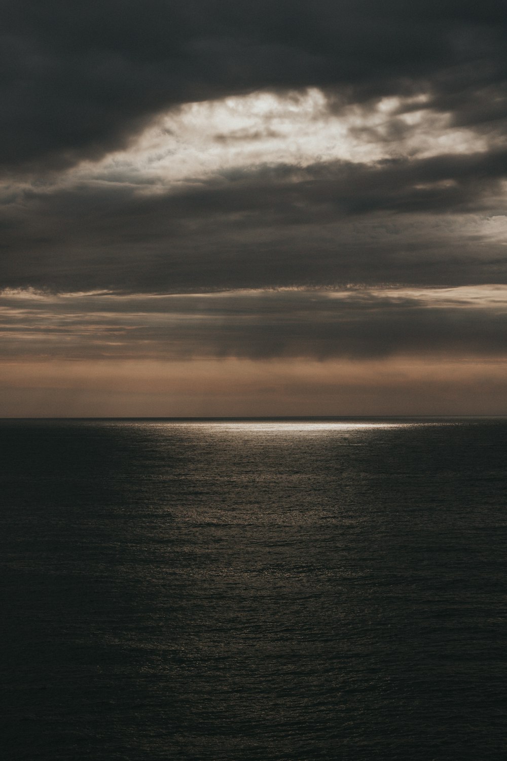 a body of water with a cloudy sky above it