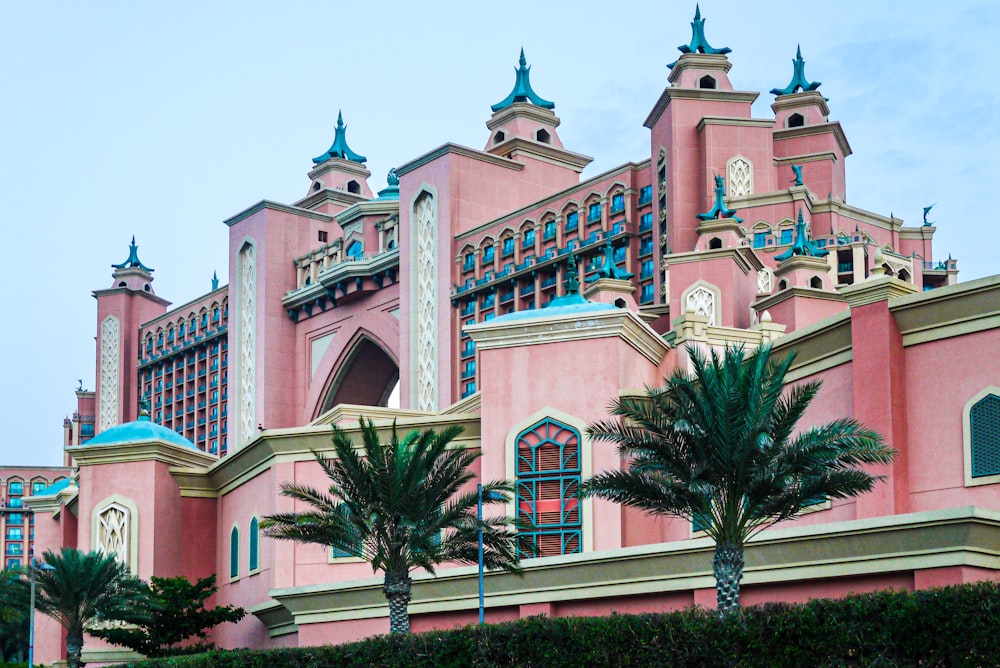 a pink building with palm trees