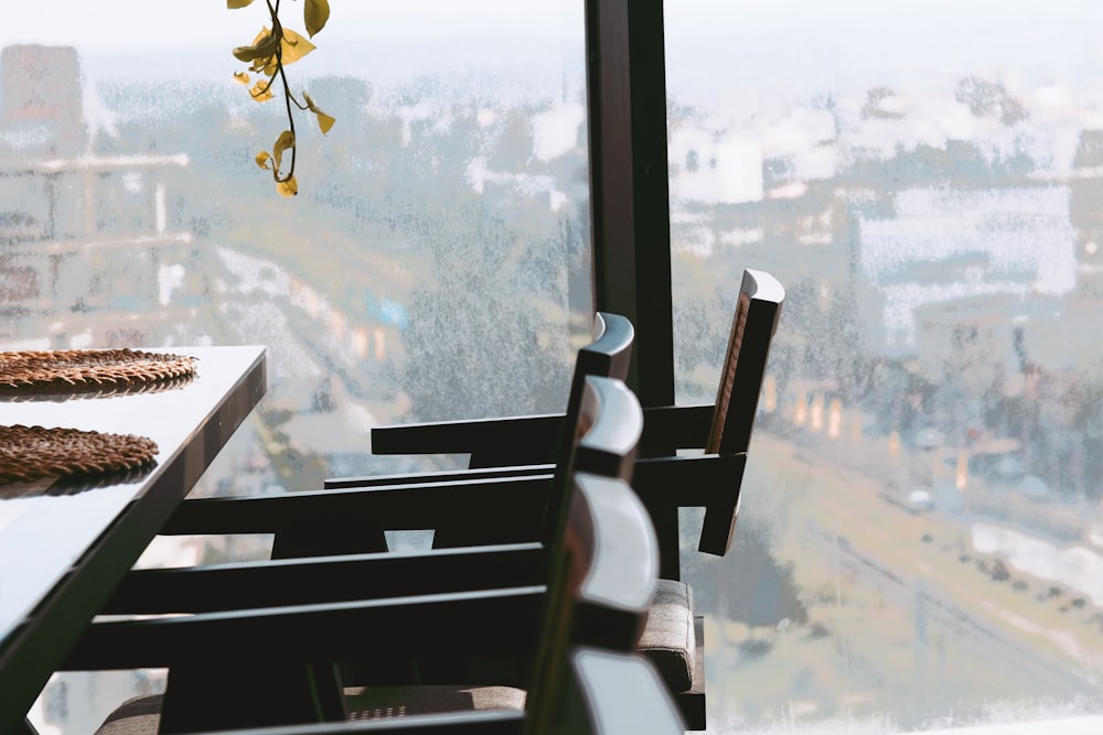 una silla y una mesa con un jarrón junto a una ventana