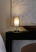 Minimalist wooden lamp with soft natural finish glowing warmly in an organic styled room.