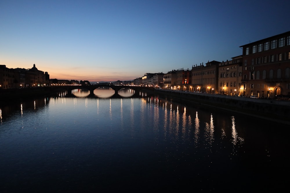 a river with a bridge and buildings along it