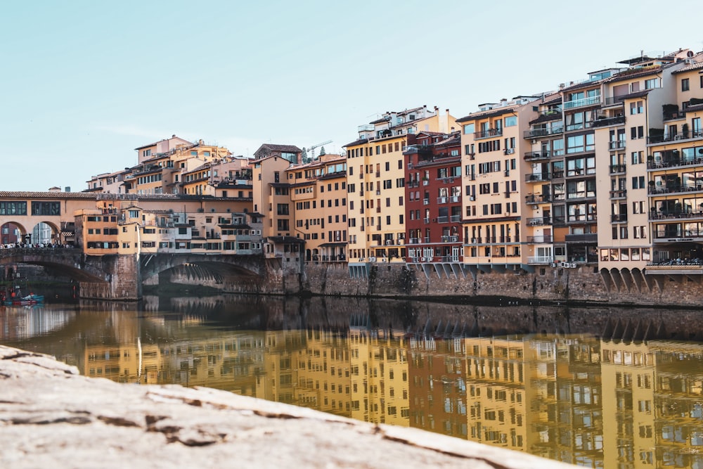 a body of water with buildings along it with Kowloon Walled City in the background