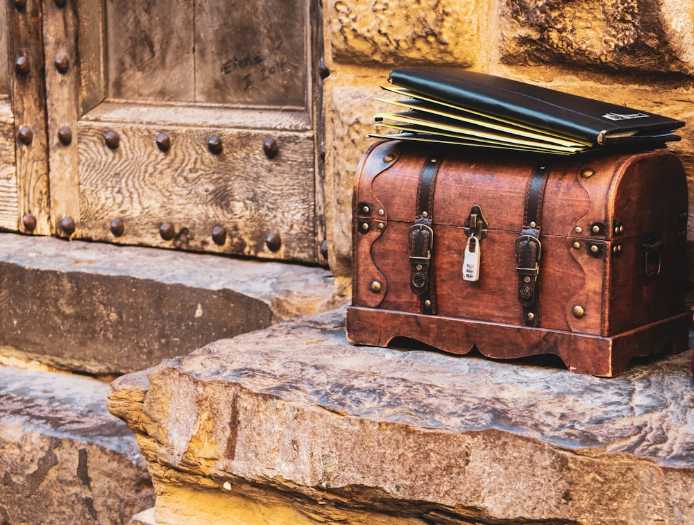 a suitcase sits on top of a rock