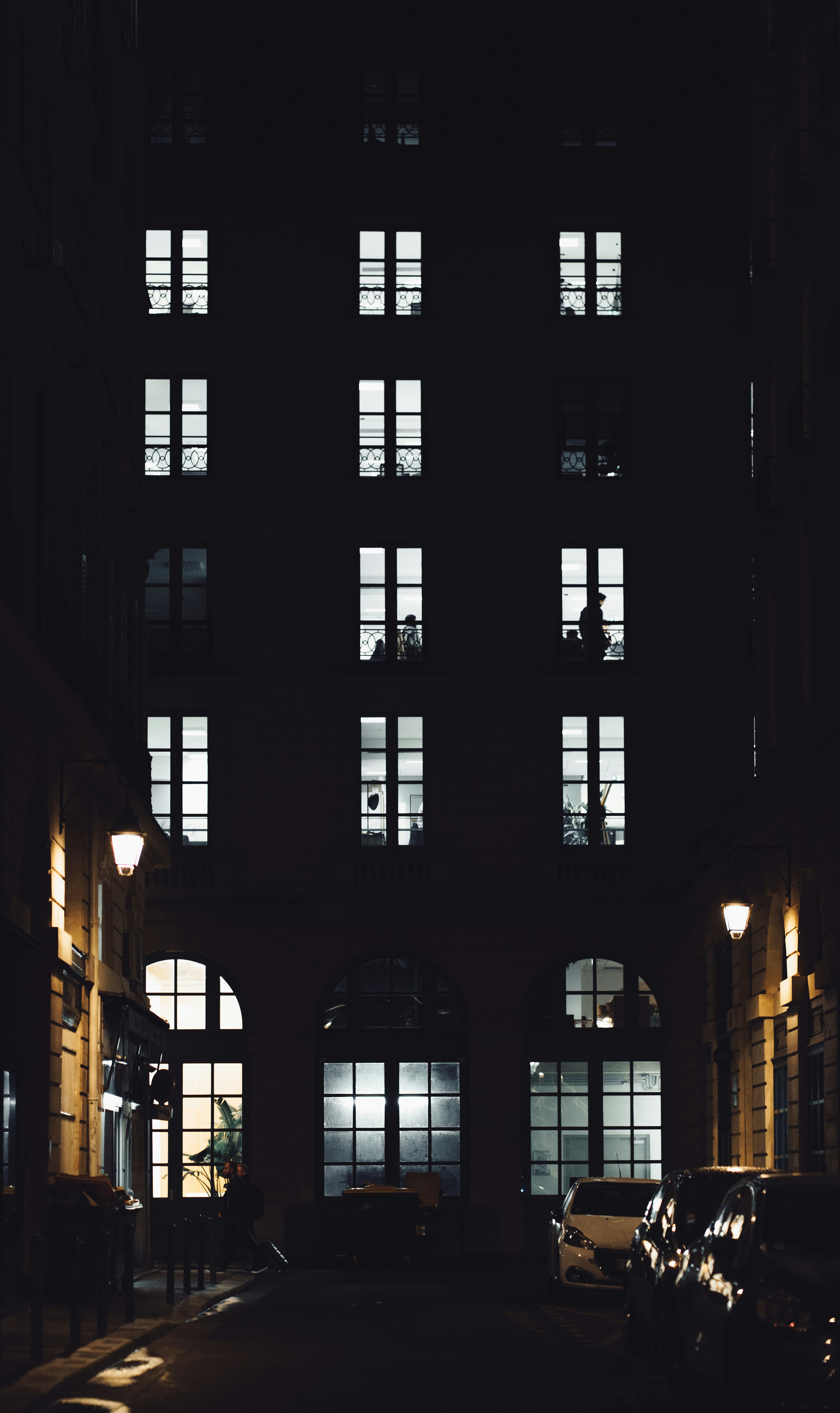 un bâtiment avec des fenêtres et des voitures garées devant