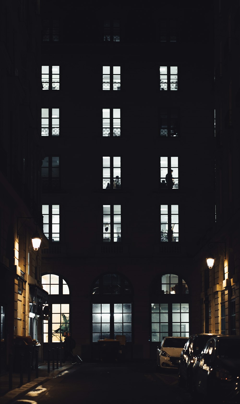 a building with windows and cars parked in front of it