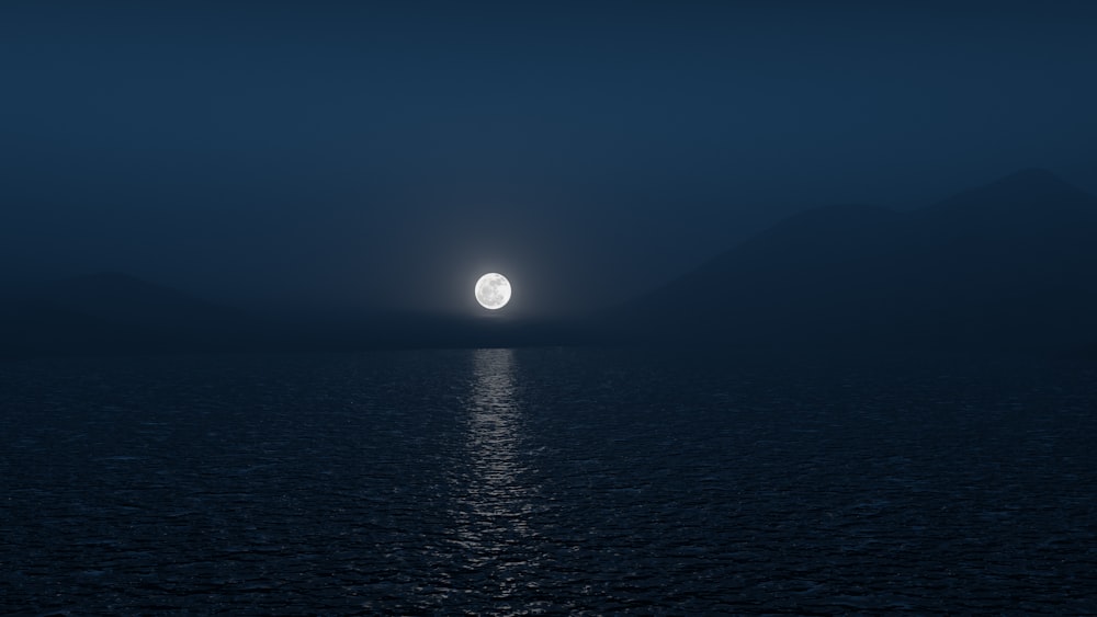 a body of water with a moon in the sky