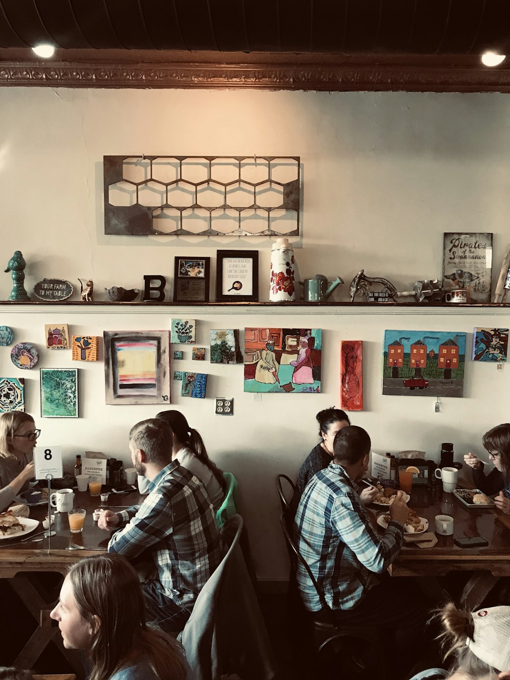 um grupo de pessoas sentadas em uma mesa com quadros na parede