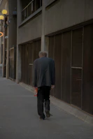 A solitary figure walking through a dimly lit urban alley, embodying resilience and determination.