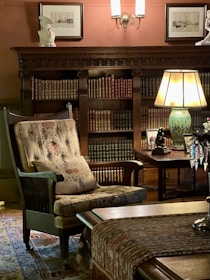 A cozy armchair tucked next to a bookshelf filled with classic fiction novels under soft evening light.