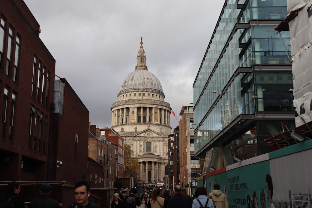 a large building with a dome and a crowd of people walking around