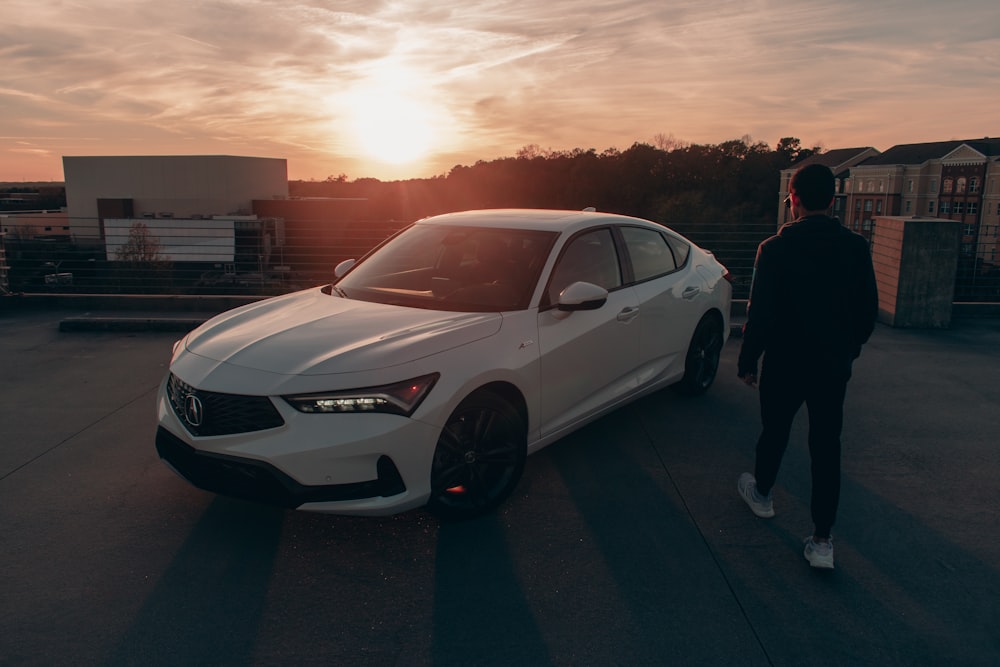 a man walking next to a white car