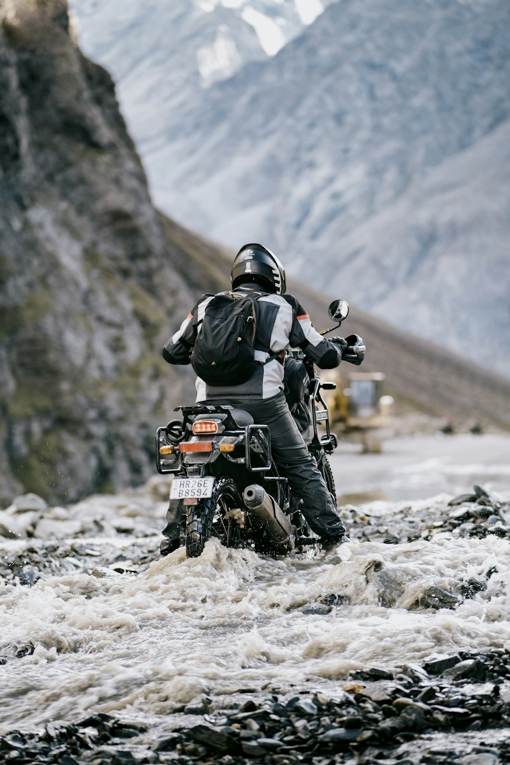 a man on a motorcycle in the mountains