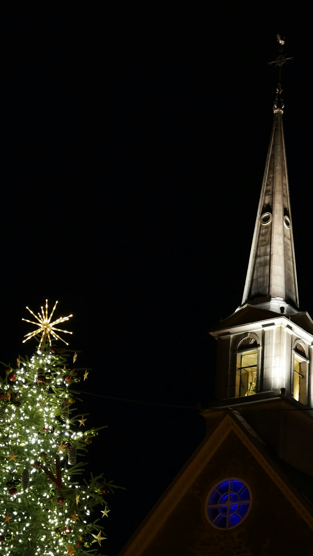 a tree with lights and a building in the background