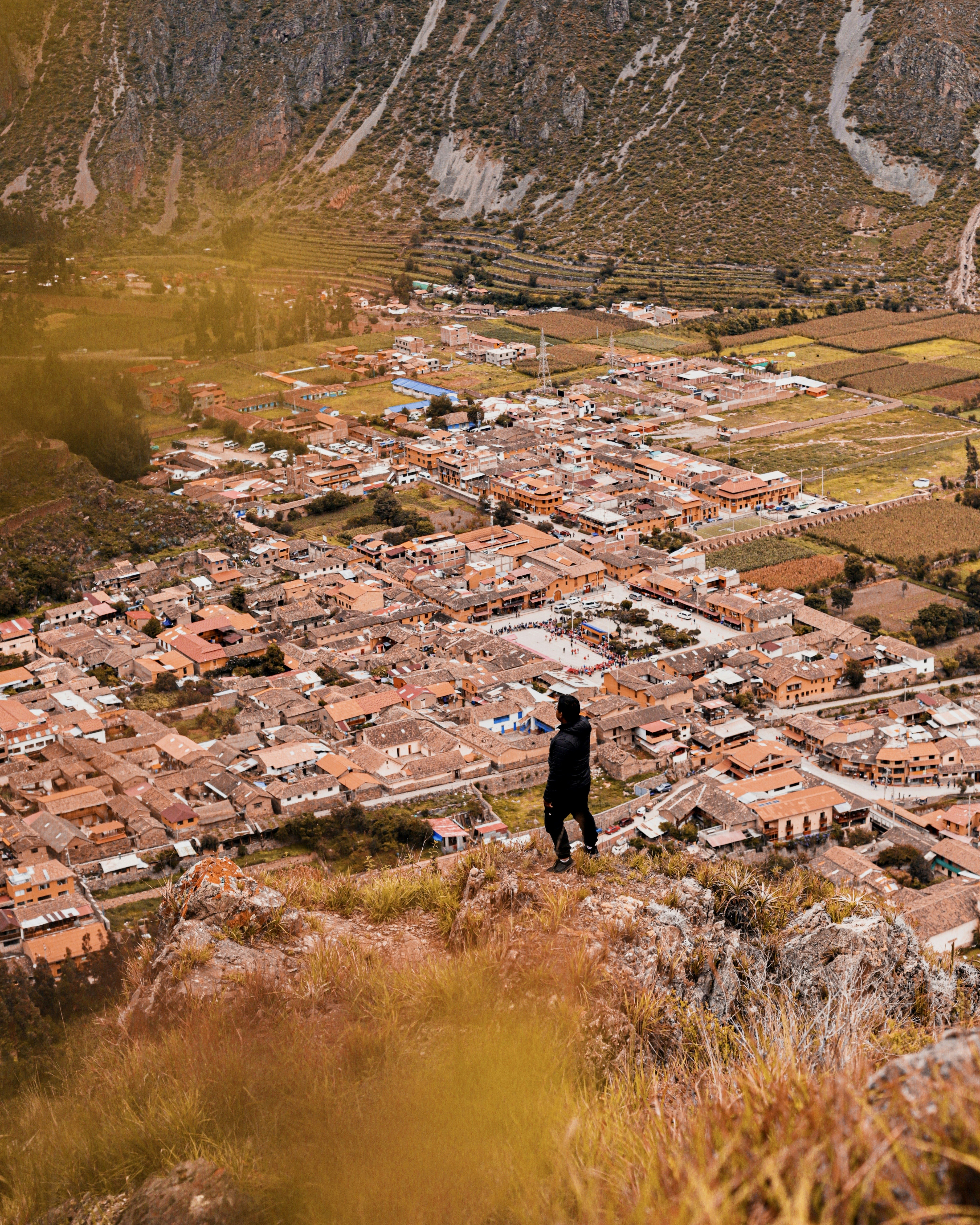 Una persona parada en una colina con vistas a una ciudad