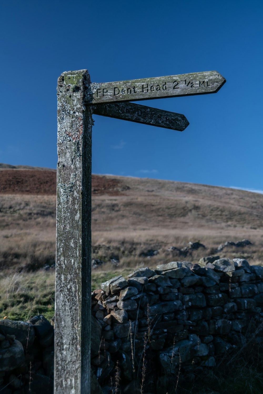 a signpost with a rocky landscape in the background