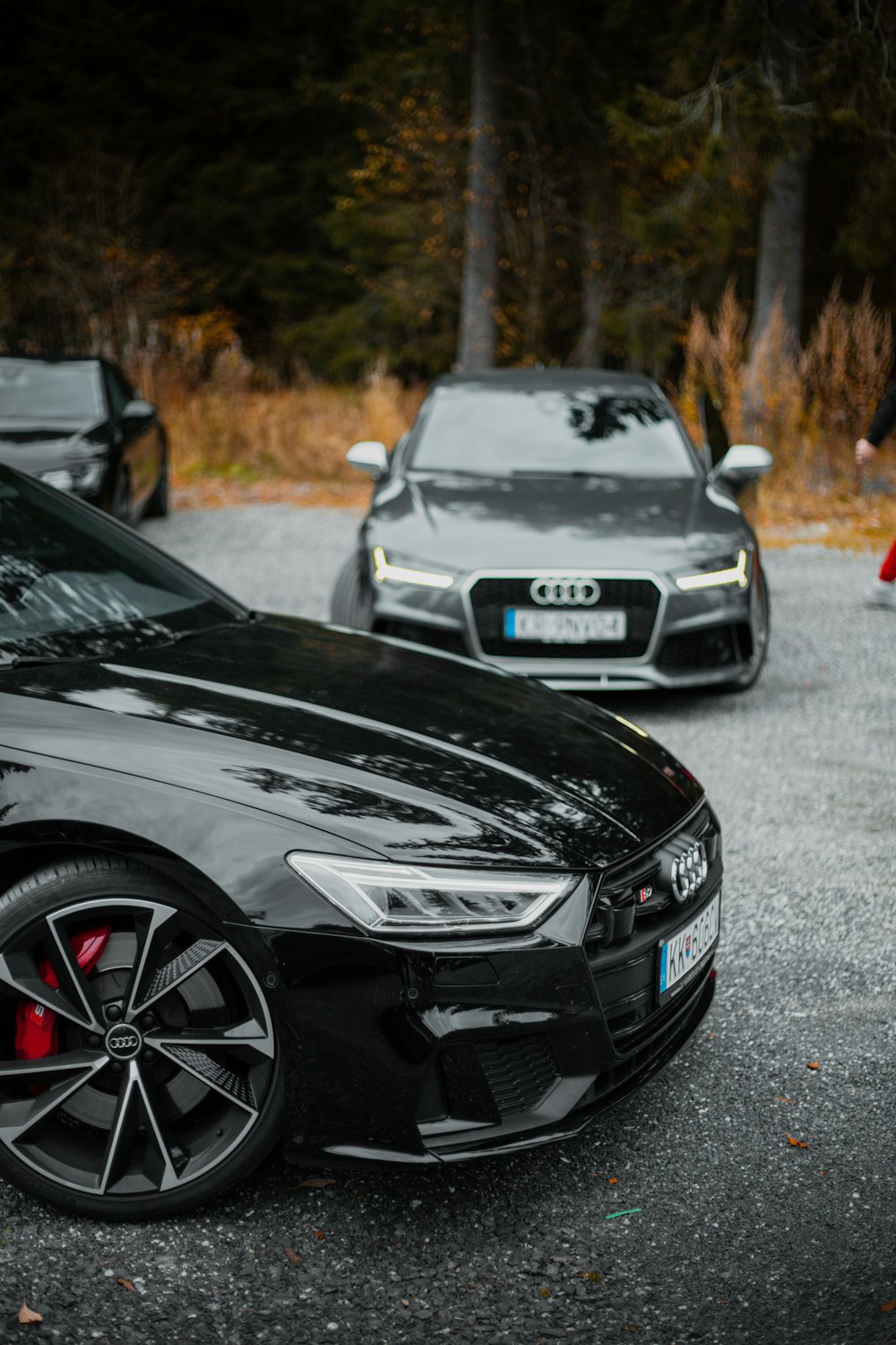 a couple of cars parked in a parking lot with trees in the background