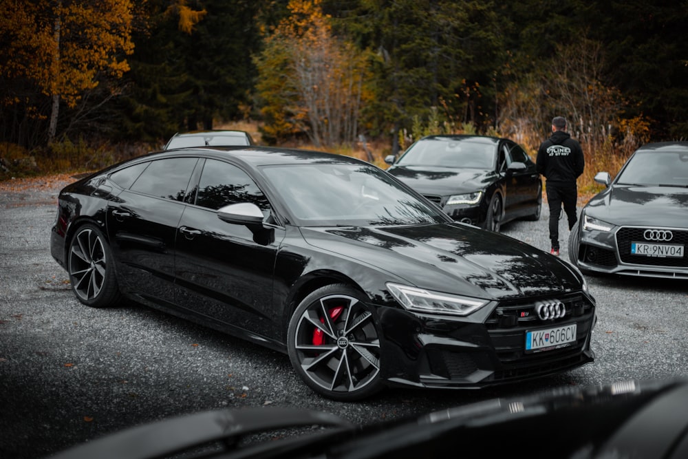 a person standing next to a black car