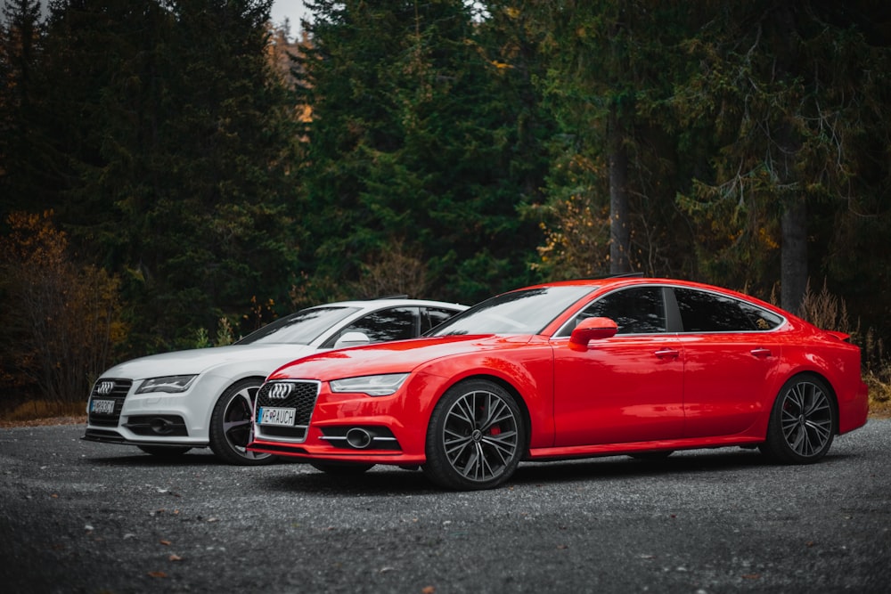 a red sports car parked next to a white car