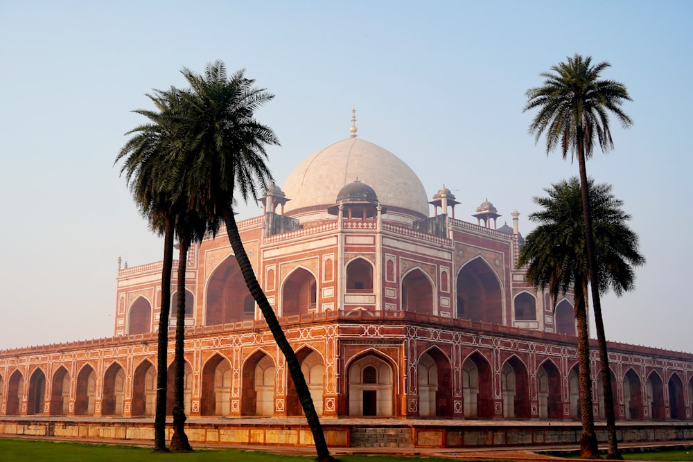 a large building with palm trees in front of it