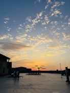 Wide shot of freshly milled asphalt with heavy equipment parked nearby at sunset.