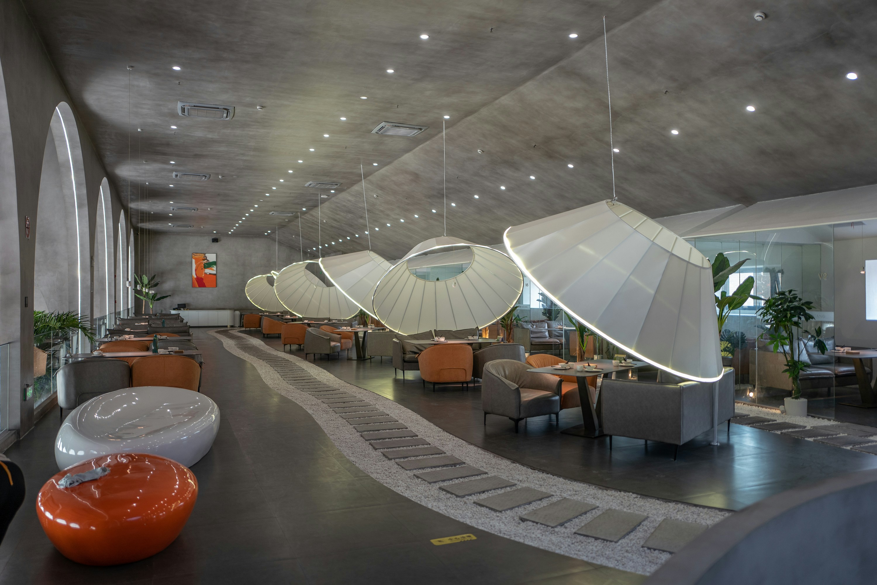 a room with a large glass ceiling and a round table with chairs