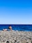 A couple relaxing on a sunbed by the ocean.