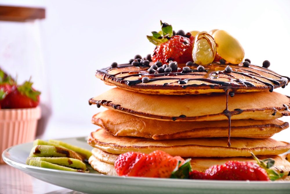 Una pila de panqueques con fruta encima