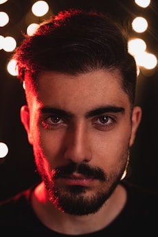 Portrait of Jean de Dieu Tchegnèbe, aka Man No Lap, in a cinematic setting with warm golden lighting.