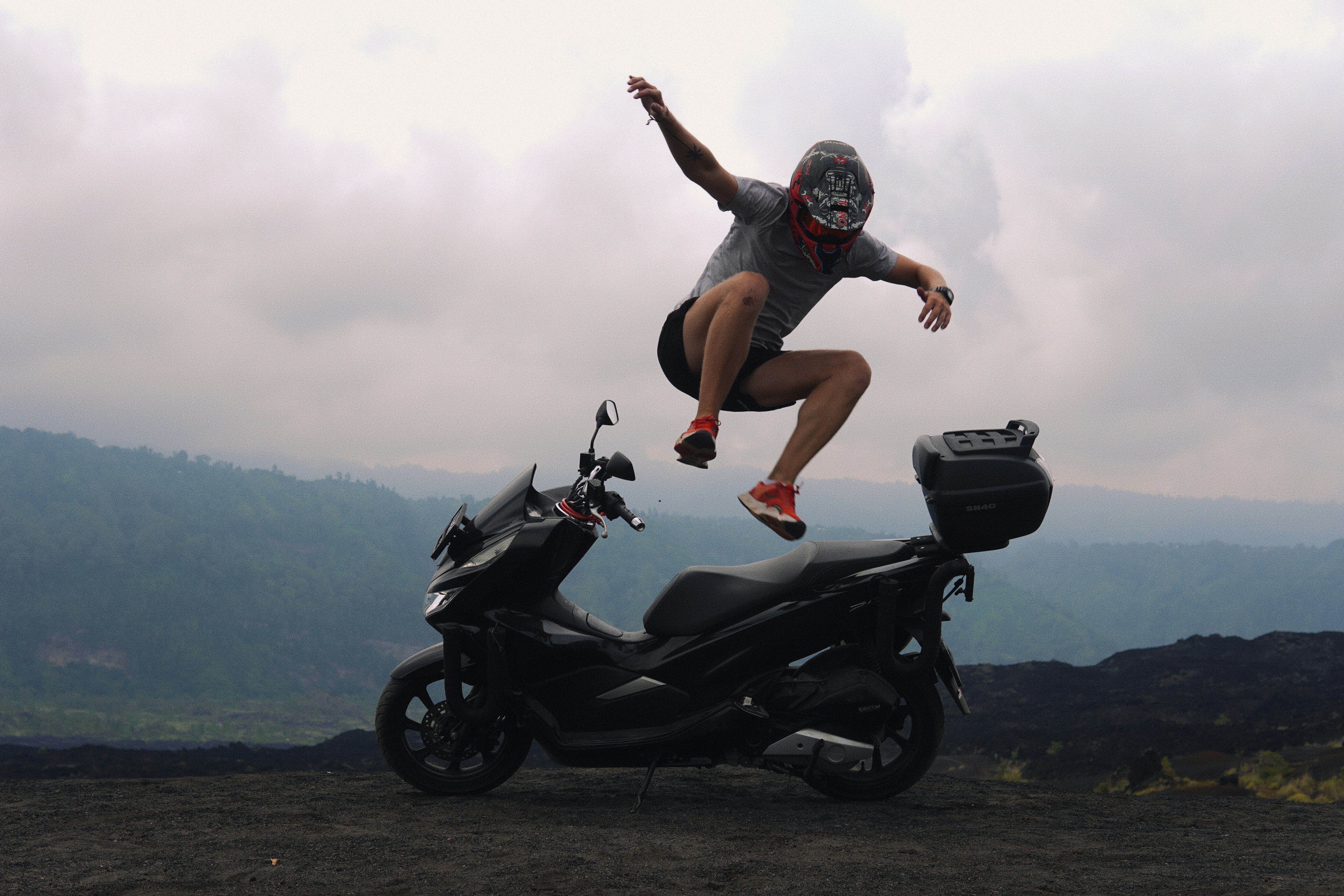 Seorang pria melompat dari sepeda motor