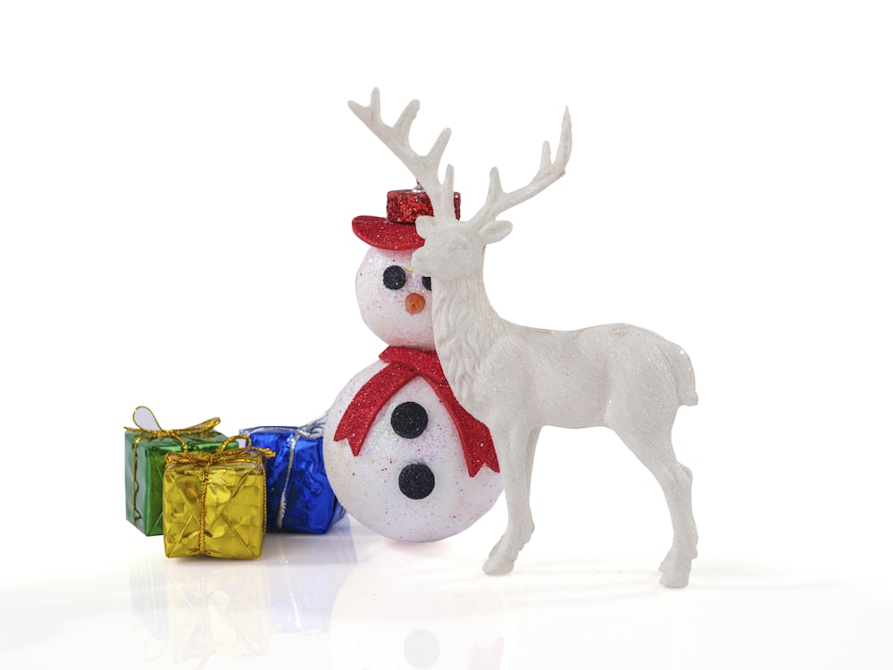 a white reindeer with a red hat and a red scarf