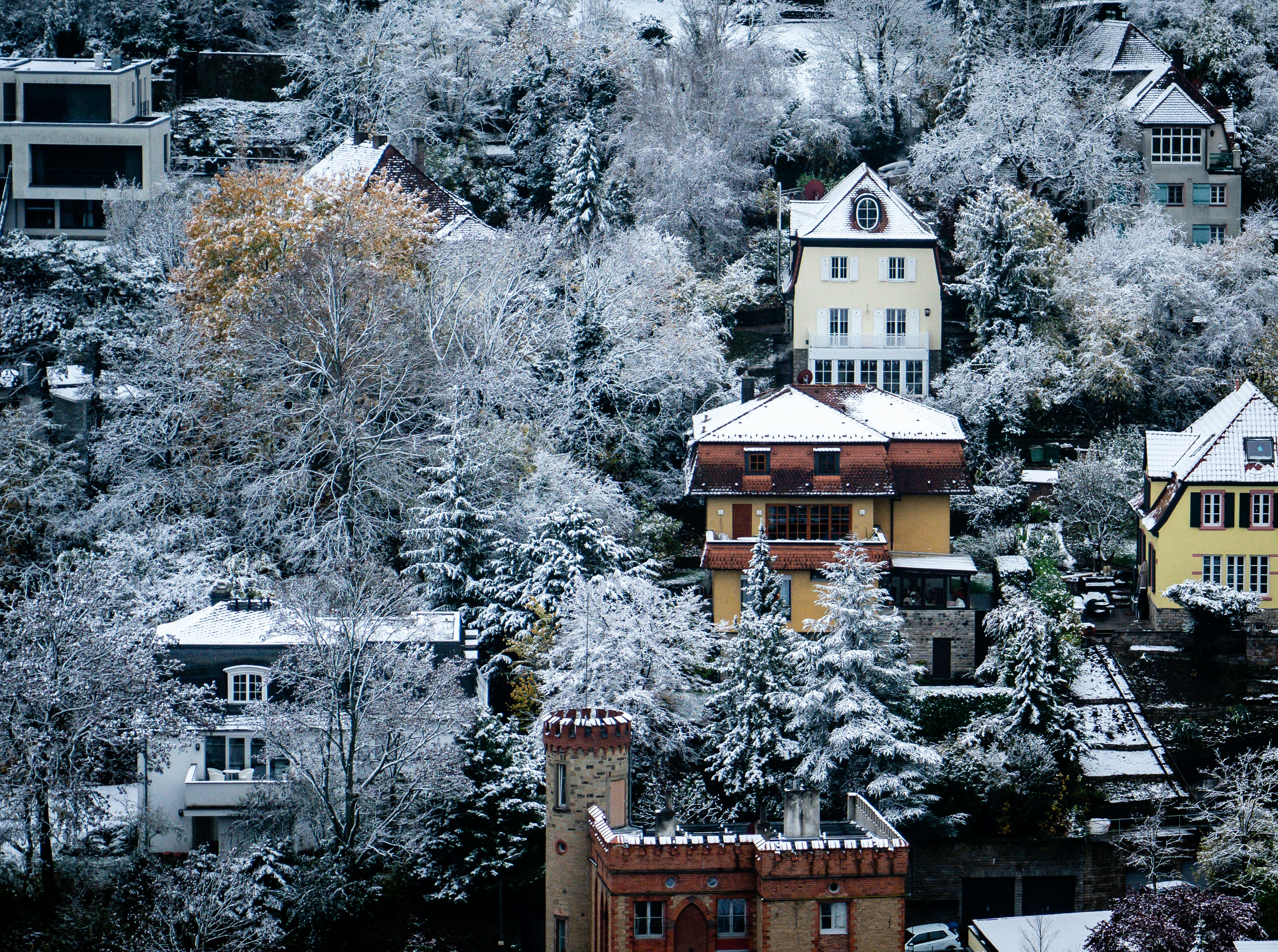 a group of buildings with snow on the roofs and trees around them with Ahwahnee Hotel in the background
